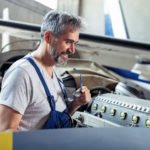 Aircraft maintenance mechanic inspects  plane engine